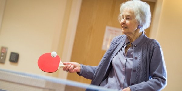 Female resident holding table tennis paddle