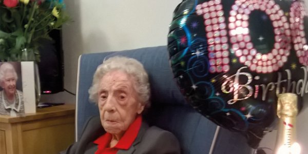 Joyce with balloon, and cake with candles