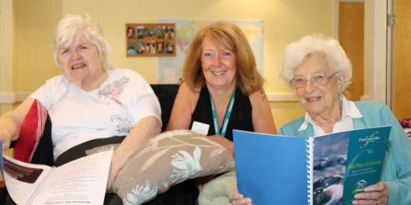 Residents reading the Reflections poetry book with Leisure and Lifestyle manager Sue Faulkner