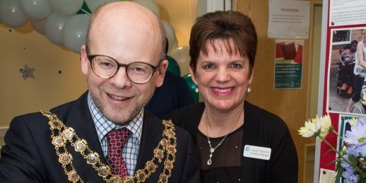 Mayor cutting cake with team member from Lewin House