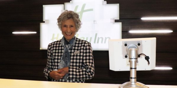 Pat smiling behind Holiday Inn reception
