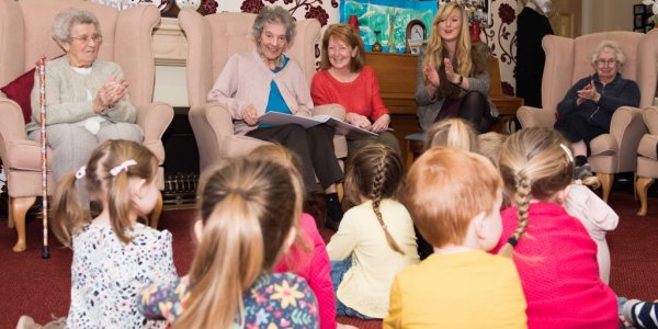 Care home residents and tots share treasured reads during National Storytelling Week