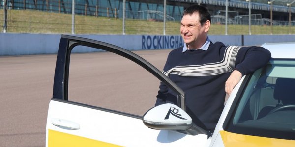 Shaun leaning on car and smiling