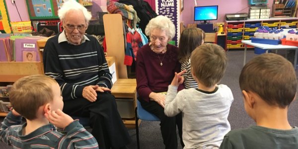 Group of children and residents smiling and reading books