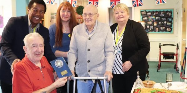 Residents and care workers holding trophy for winning pie