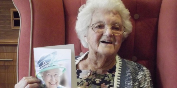 Kathleen holding birthday card from HM Queen