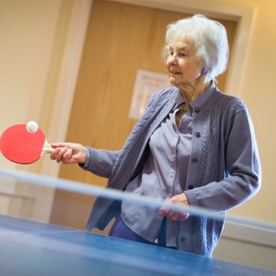 Female resident holding table tennis paddle