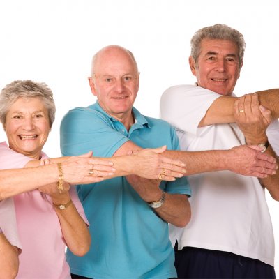 Two women and two men standing in a row stretching their right arm