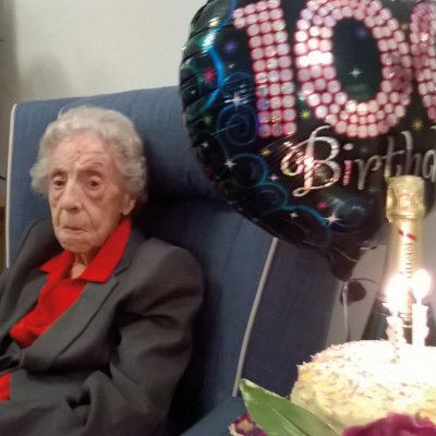 Joyce with balloon, and cake with candles