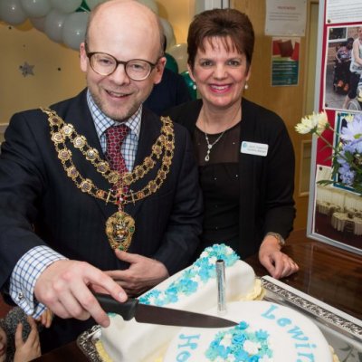 Mayor cutting cake with team member from Lewin House