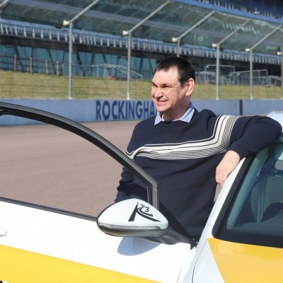 Shaun leaning on car and smiling