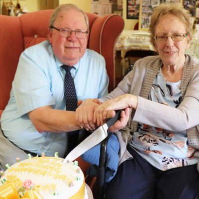 Roy and Jean wedding photo smiling cutting cake