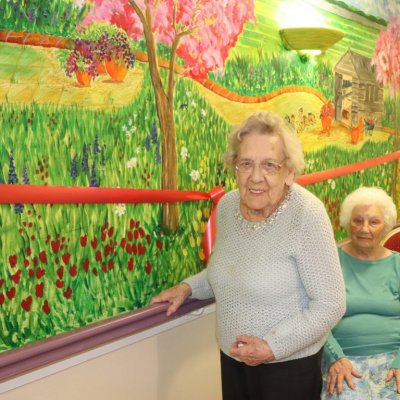 Residents standing by wall mural