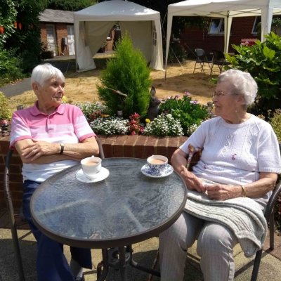 Phyllis and Jean chatting over a cup of tea