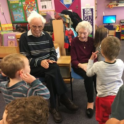 Group of children and residents smiling and reading books