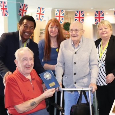 Residents and care workers holding trophy for winning pie