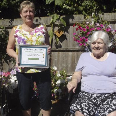 Karen White winner of Gardener of the Year, Fremantle in Bloom, holding her certificate between two female residents