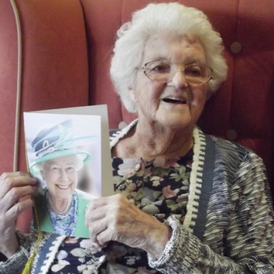 Kathleen holding birthday card from HM Queen