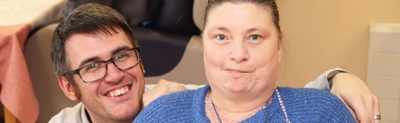 Assistant manager with service user, smiling